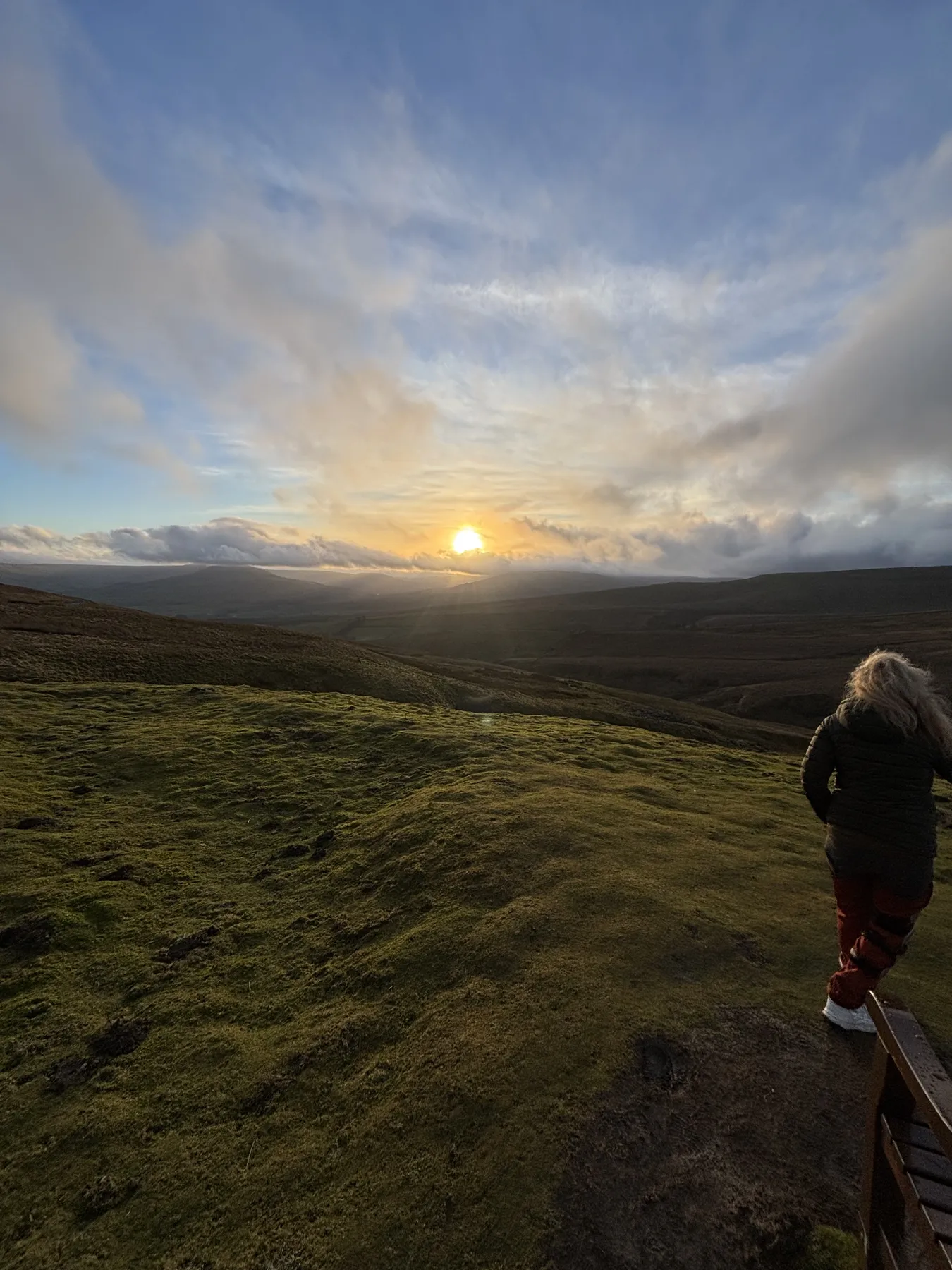A couple watching the sun set over the high Yorkshire Dales